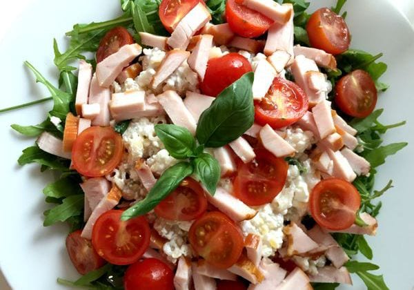Pasta salad with smoked chicken, cottage cheese and cherry tomatoes photographed from above