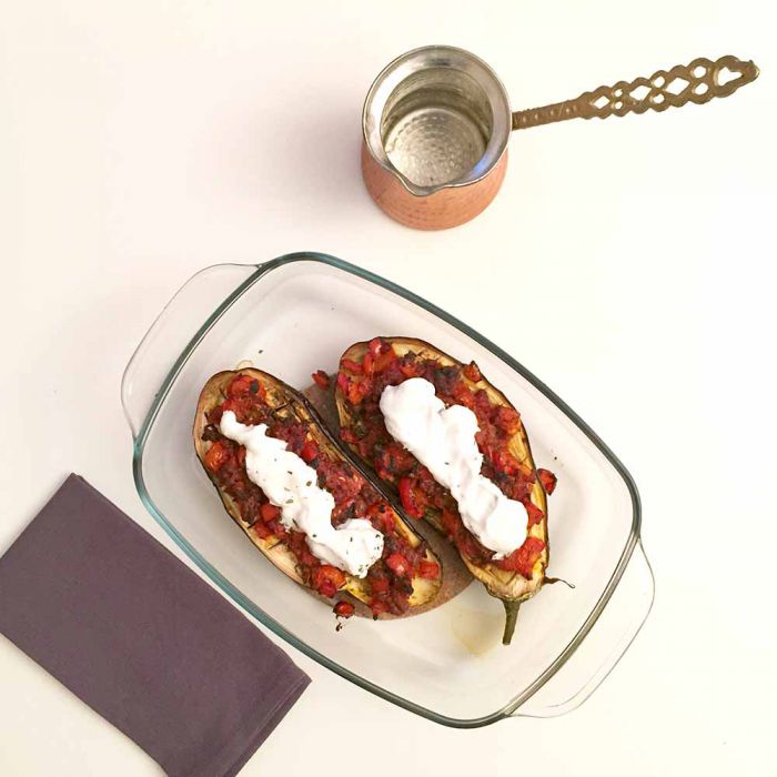 Low FODMAP stuffed eggplant in an oven dish with yoghurt on top and a cezve next to it