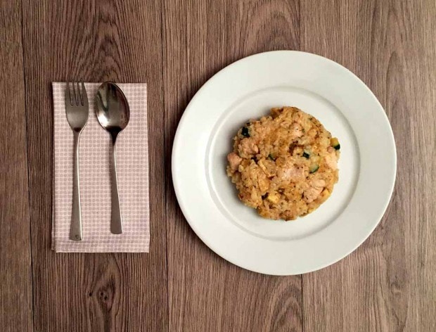 Een bord met low FODMAP risotto met zoete aardappel met bestek ernaast op een servet