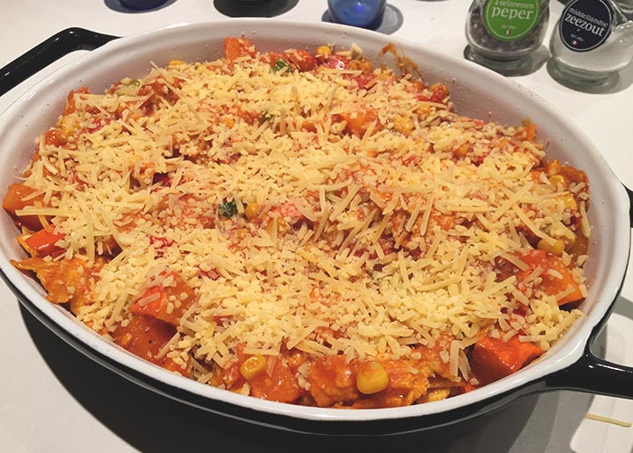 A Mexican casserole with pumpkin and grated cheese on top