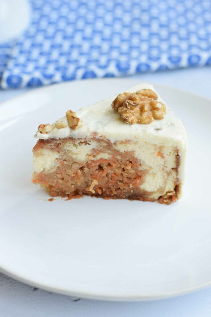 A piece of gluten-free carrot cake cheesecake on a plate
