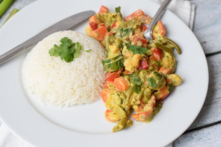 A plate with low FODMAP yellow curry and a fork in it