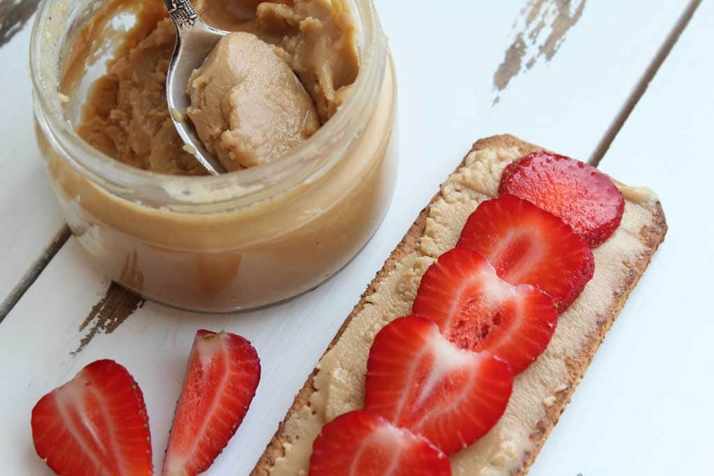 A cracker with peanut butter and strawberry