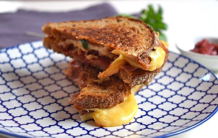 Two Italian grilled cheese sandwich on sourdough bread on a plate