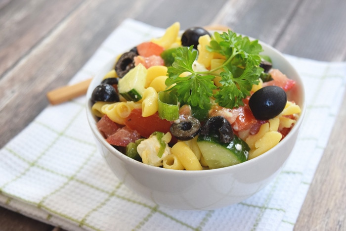 A bowl with low FODMAP Greek pasta salad photographed from the side
