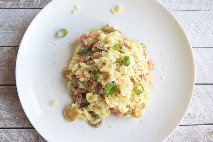 Mushroom and prosciutto risotto on a plate photographed from above
