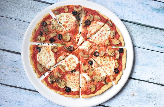 De beste glutenvrije pizza ooit op een groot bord in stukjes