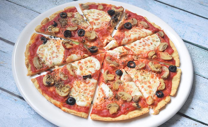 A gluten-free pizza with mozzarella, mushrooms and olives