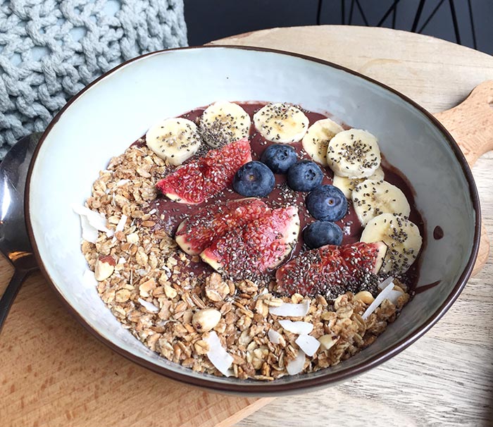 A smoothie bowl with bananas, blueberries and muesli