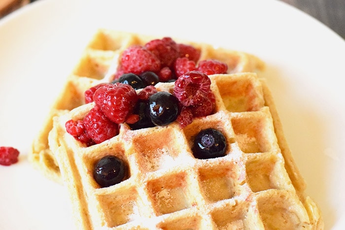 Two healthy low FODMAP waffles with red fruit on top