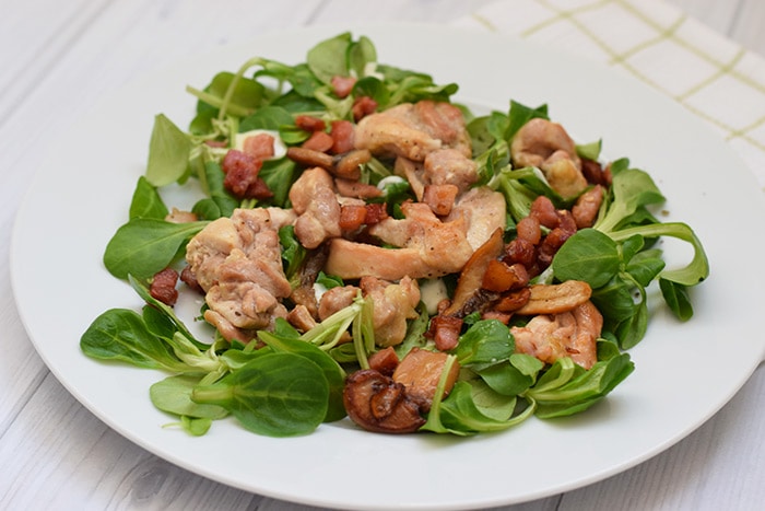 A plate of low FODMAP salad with chicken thigh, mushrooms and bacon 