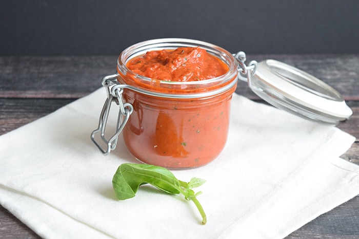 Low FODMAP roasted red pepper dip in a jar on a white napkin