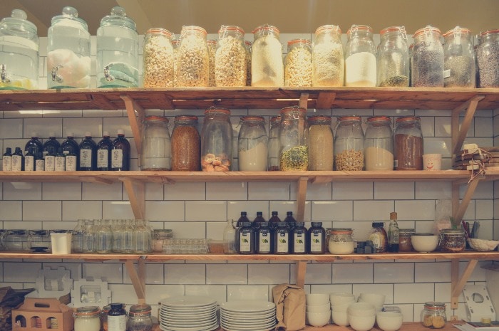 A pantry with lots of different jars in it