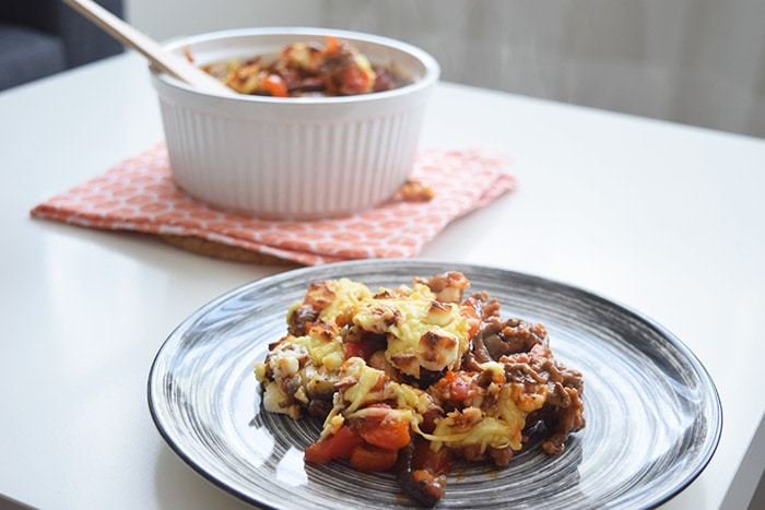 low fodmap eggplant lasagna on a plate with an oven dish behind it