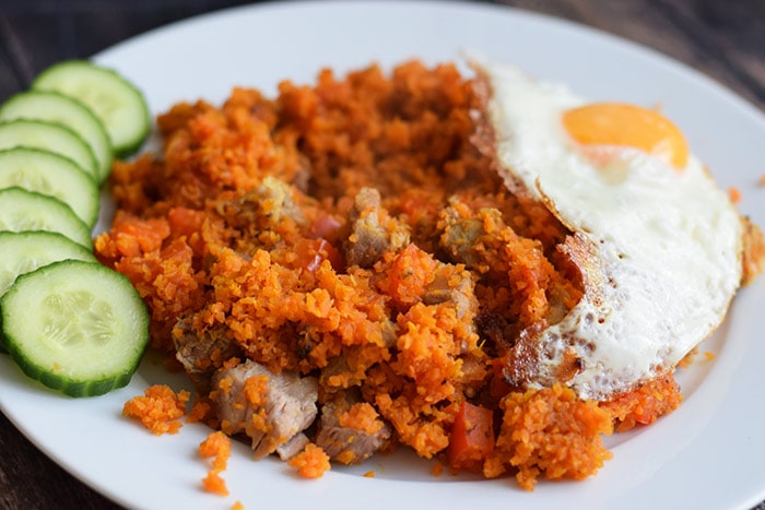 Low FODMAP carrot rice nasi goreng with meat, cucumber and a fried egg