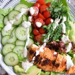 Een low FODMAP salade met gegrilde kip, tomaatjes, komkommer en yoghurt dressing