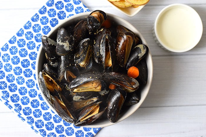 low FODMAP mussels in white wine sauce in a bowl with sauce next to it