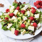 Een low FODMAP salade met frambozen en brie op een bord