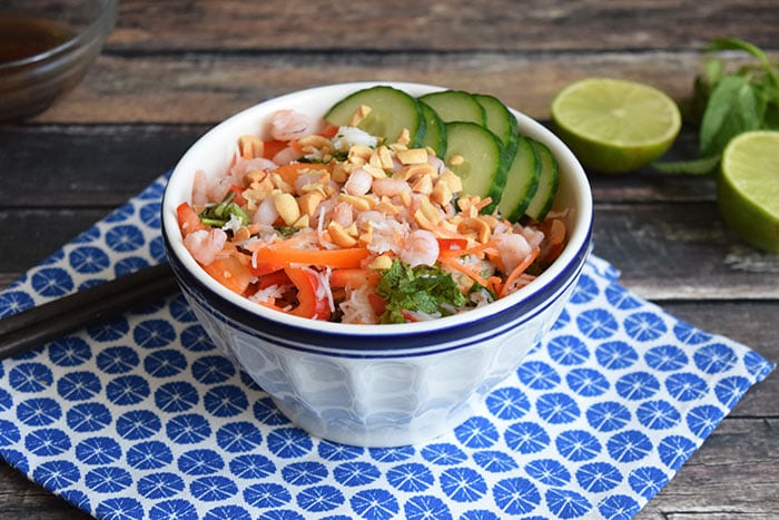A low FODMAP spring roll bowl with shrimps, cucumber, bell pepper and fresh herbs