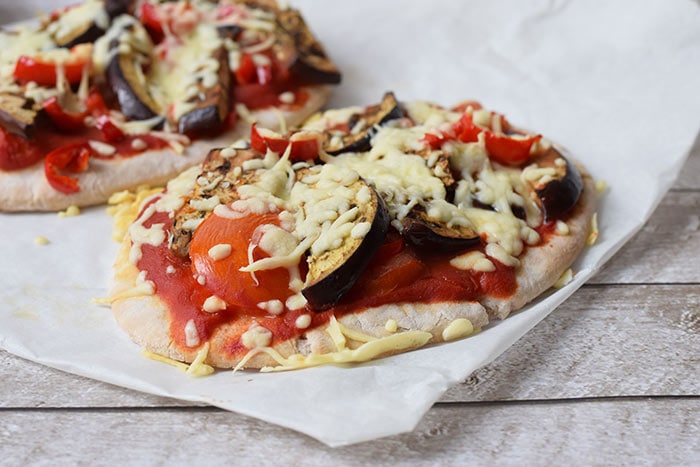 Een low FODMAP pita pizza met aubergine, tomaat en geraspte kaas