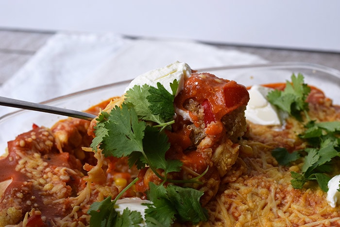 A low FODMAP Mexican quinoa casserole with a spoon taking a bit out of it