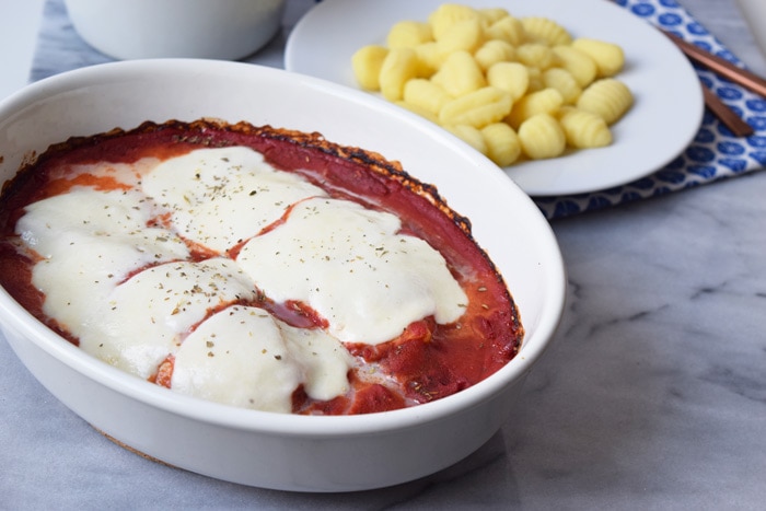 mozzarella kip in tomatensaus in een ovenschaal met een bordje gnocchi ernaast