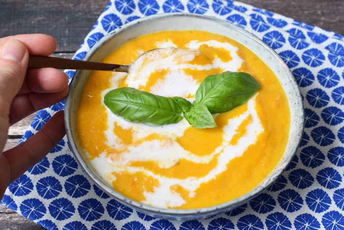 A bowl of low FODMAP carrot soup with ginger and coconut milk