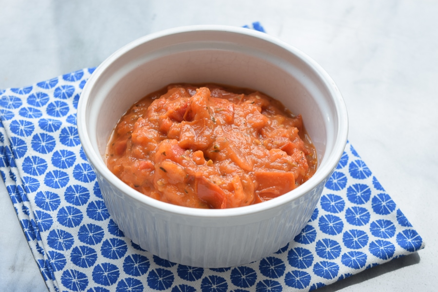 Low FODMAP pasta sauce in a bowl standing on a blue napkin