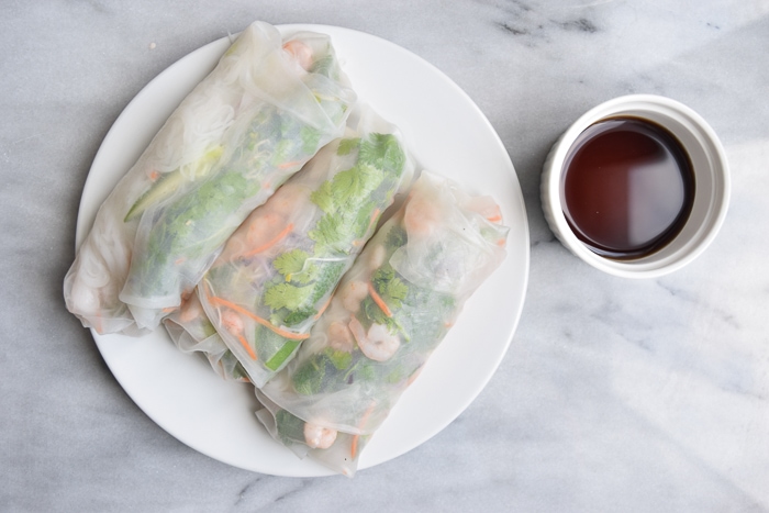low FODMAP spring rolls with shrimps on a plate with a dip sauce next to it