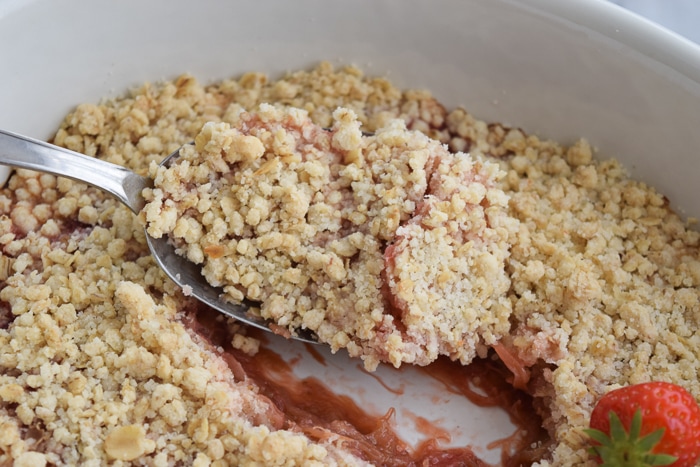 low FODMAP rhubarb crumble in a dish with a spoon in it