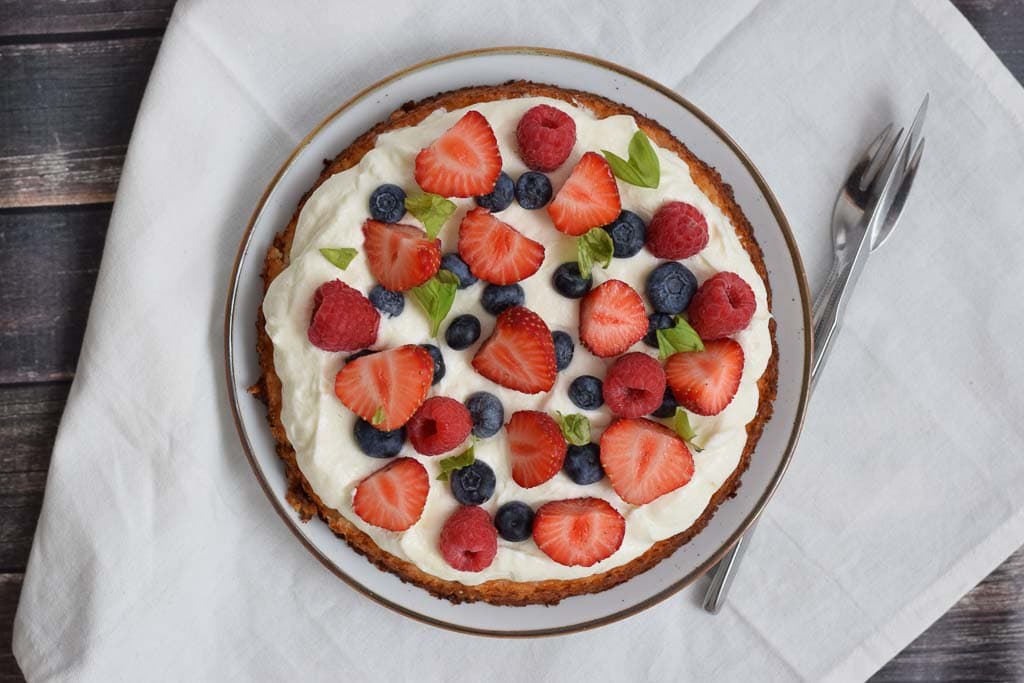 A rice pie with red fruits and cream photographed from above