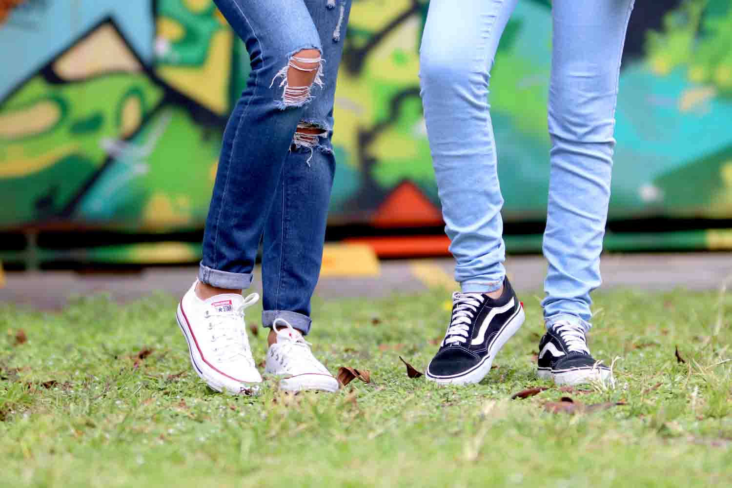 Two people wearing jeans and sneakers