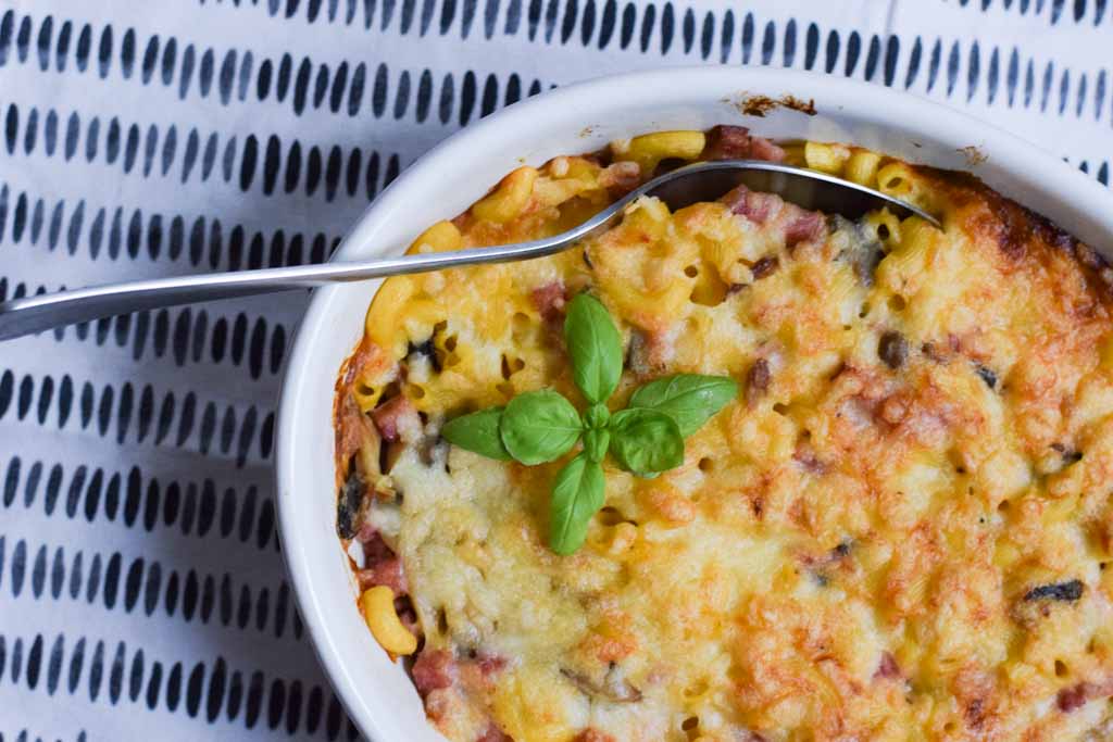 low fodmap mac and cheese casserole with ham with a spoon in it photographed from above