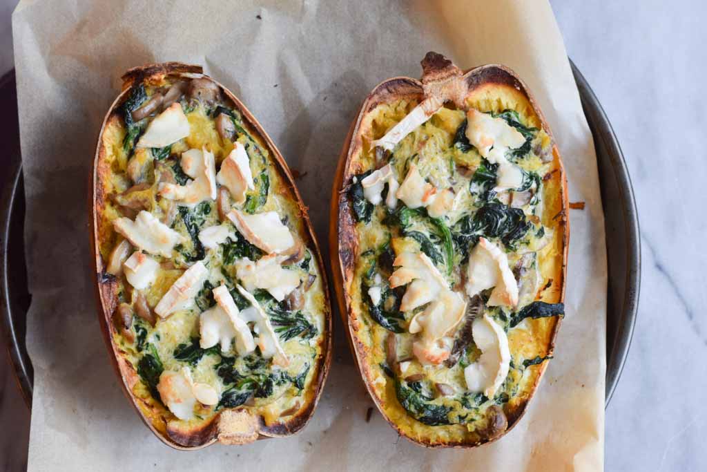Two halves of a low FODMAP spaghetti squash on a baking sheet