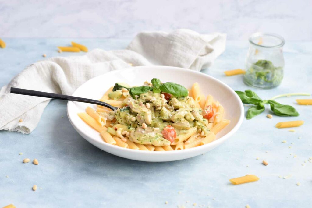A creamy low FODMAP chicken pesto pasta with tomatoes, zucchini and mushrooms