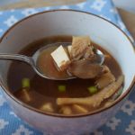 low fodmap miso soep in een kom waar iemand met een lepel een hapje uit pakt