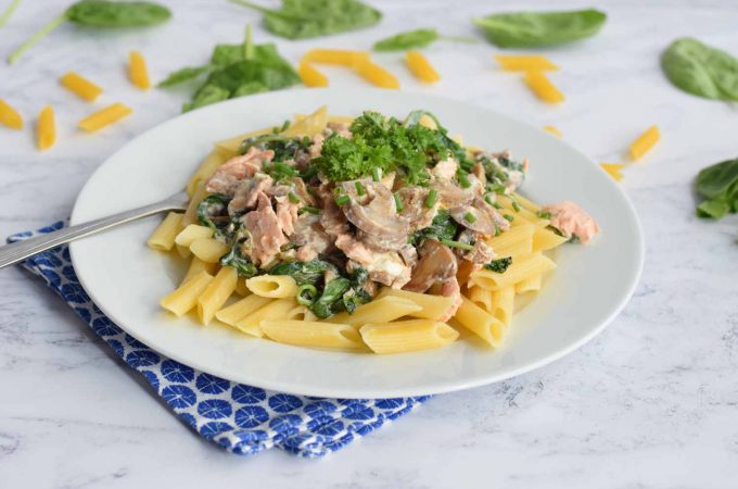 Low FODMAP creamy pasta with salmon and spinach on plate