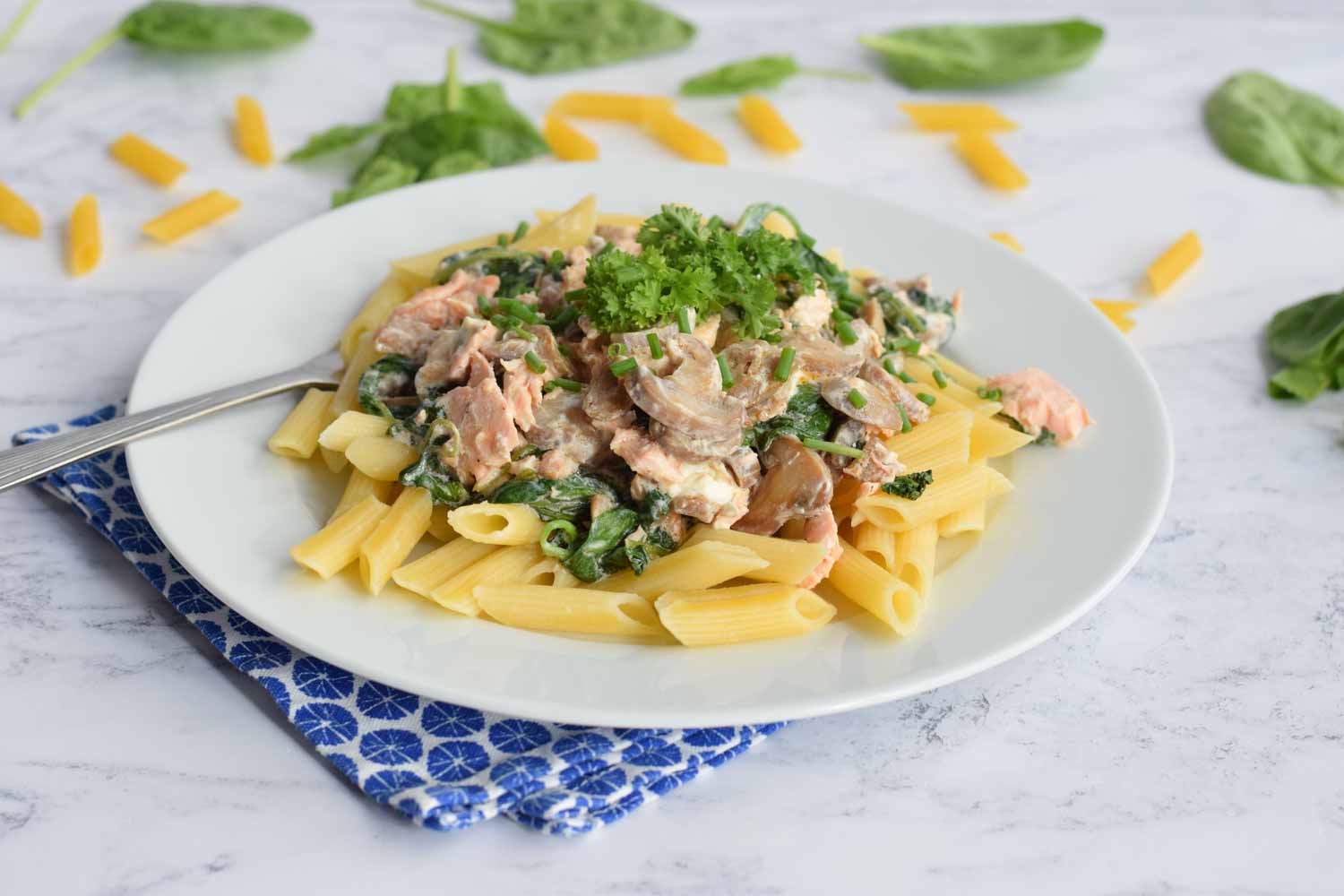 Low FODMAP creamy pasta with salmon and spinach on plate