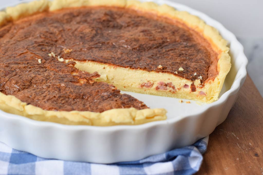 A low FODMAP quiche lorraine with a piece out of it
