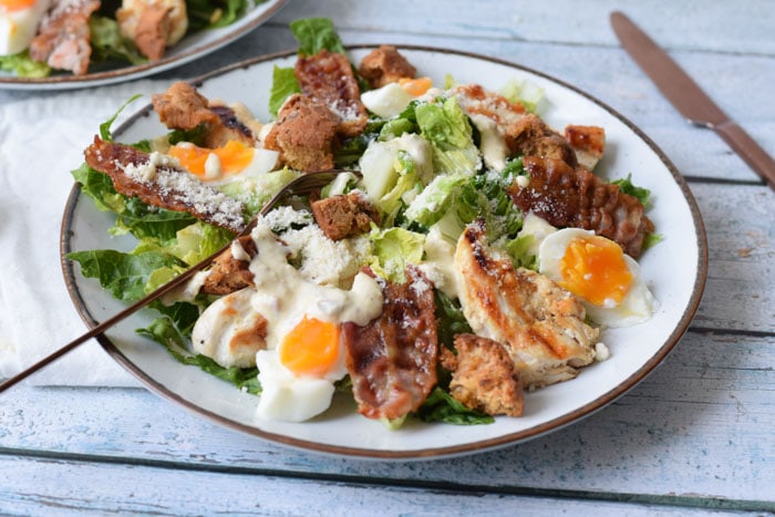 A low FODMAP caesar salad with bacon, chicken, egg and dressing