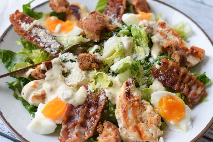 Een low FODMAP caesar salade met kip, bacon, ei en caesar dressing