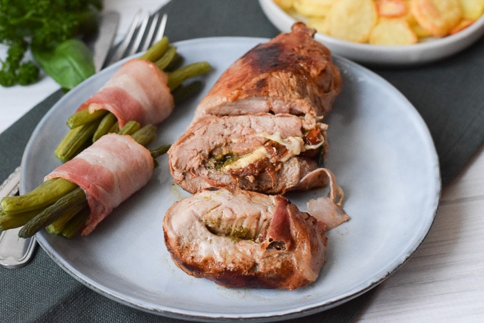 A plate with low FODMAP stuffed pork tenderloin and green beans with ham
