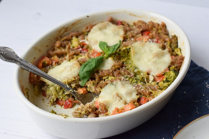 A low FODMAP pasta pesto casserole with a spoon in it