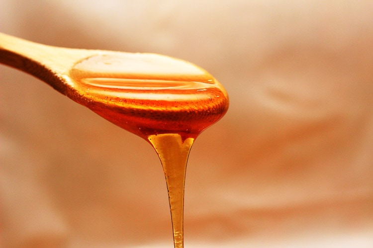 Een lepel waar honing vanaf druipt
