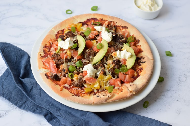 Gluten-free Mexican pizza on a plate with avocado on top