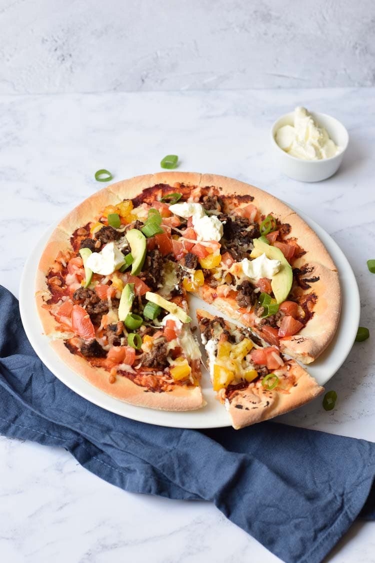 Gluten-free Mexican pizza with one slice out