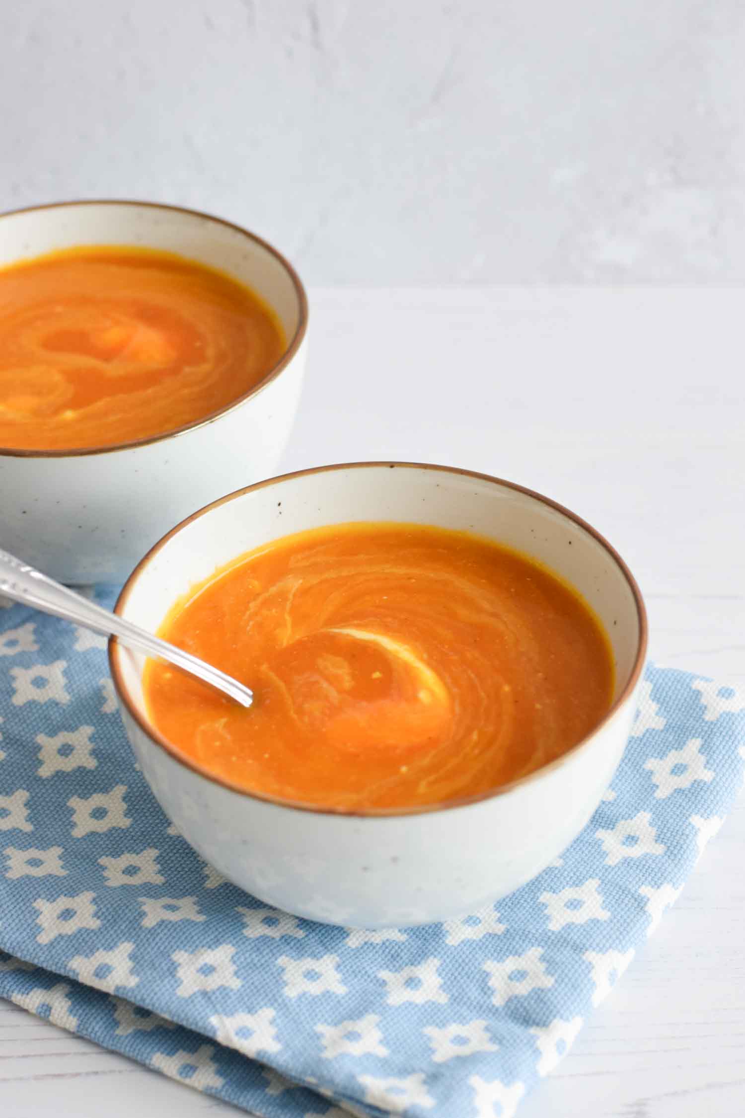Low FODMAP pumpkin tomato soup in a bowl with a spoon in it