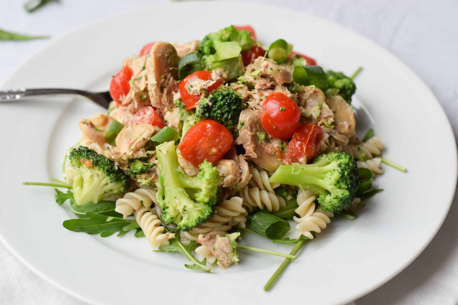 A plate of low FODMAP tuna pasta with a fork in it