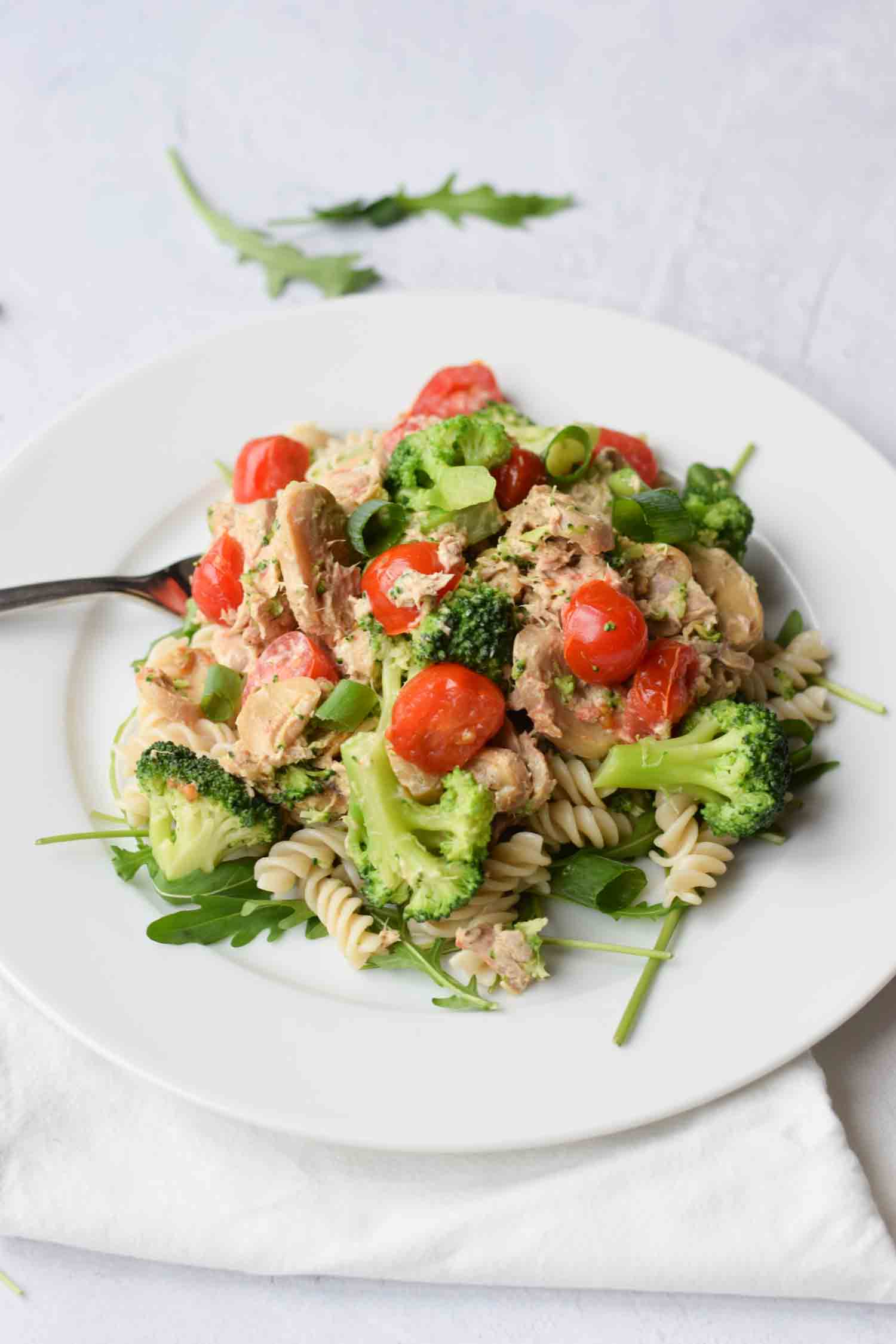 Low FODMAP creamy tuna pasta on a plate with tomatoes and broccoli