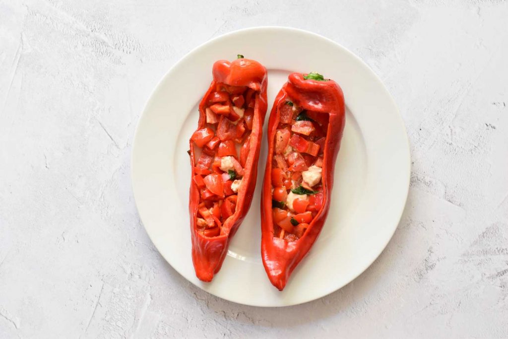 Two grilled low FODMAP stuffed pointed peppers from the BBQ on a plate